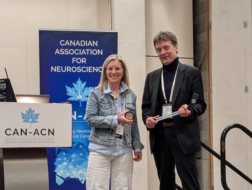 Melanie Woodin passes the CAN hockey stick to Doug Zochodne, incoming CAN President